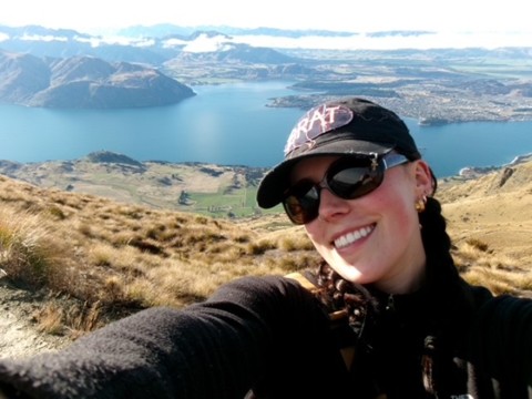 Woman (Remy) taking a selfie with mountains and lake behind her.